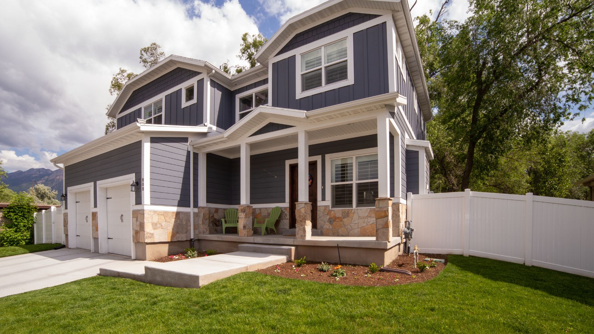 A blue and white house with a white fence