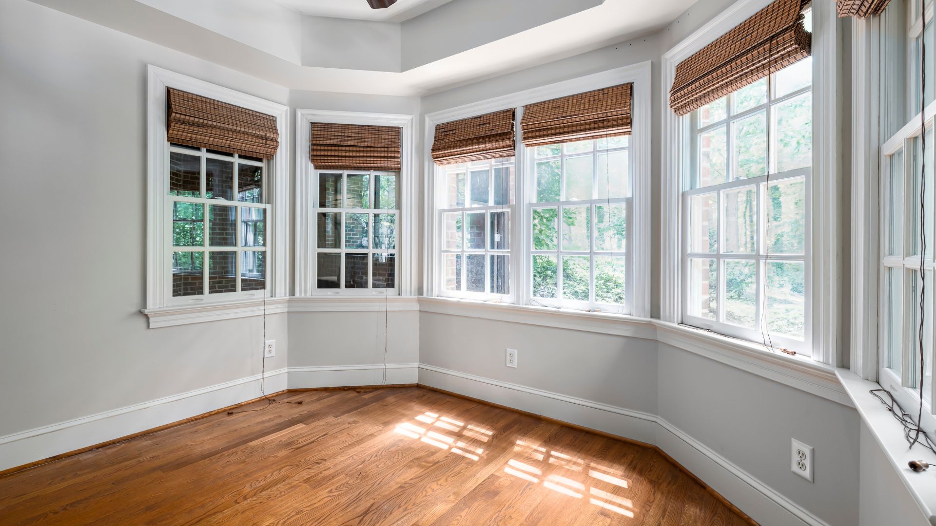 An empty room with wood floors and windows